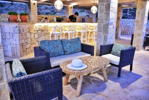 a patio with chairs and a table and a bar at Petani Bay Hotel - Adults Only in Vóvikes
