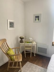 a bedroom with a desk and a chair and a table at Ancien Relais de Poste The Old Post Office in Saint-Martial-dʼAlbarède