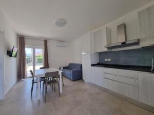 a kitchen and living room with a table and chairs at Residence La Voce del Mare in Paestum