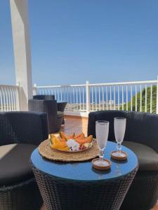 a table with a plate of food and two wine glasses at La casita in Los Menores