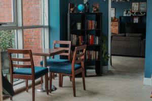 a table with two chairs and a book shelf with books at Garden Lane Backpackers in Dublin