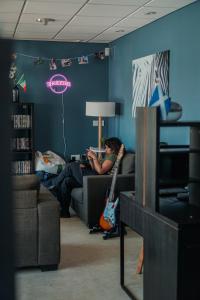 a person sitting on a couch with a guitar in a living room at Garden Lane Backpackers in Dublin
