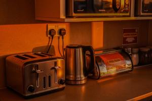 a counter top with a toaster and a coffee maker at Garden Lane Backpackers in Dublin