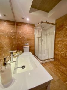 ein Badezimmer mit einem weißen Waschbecken und einer Dusche in der Unterkunft Olas y flores silvestres 1 in Castiello de Abajo + 23 Fotos