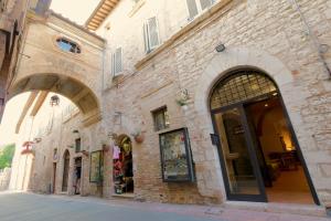 a brick building with two arches on a street at La Casina Colorata in Assisi
