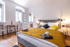 a bedroom with a large bed with a yellow blanket at Apartament Na Deptaku 23 in Lublin