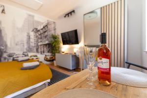 a bottle of wine sitting on a table with a glass at Apartament Na Deptaku 23 in Lublin