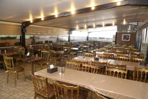 a restaurant with tables and chairs in a room at Grape Village Hotel in Amman
