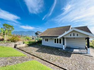 una casa bianca con tetto di Sewa Villa Puncak Gendis a Cipanas