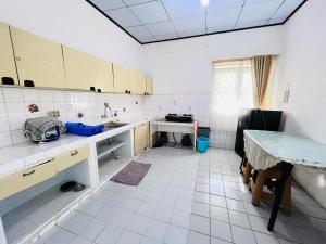 una cucina con pavimenti piastrellati bianchi e mobili bianchi di Sewa Villa Puncak Gendis a Cipanas Altre 6 foto