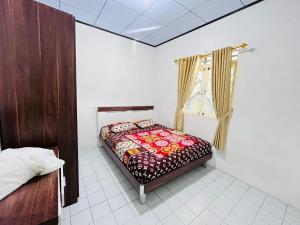 una camera da letto con un letto e una finestra di Sewa Villa Puncak Gendis a Cipanas