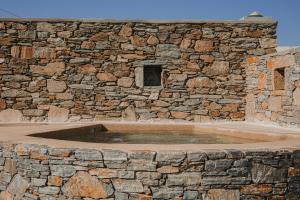 a stone wall with a large pool of water at Venue Villas - Folegandros in Áno Meriá