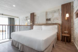 un grande letto bianco in una camera con balcone di Barceló Cappadocia a Nevşehir