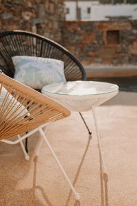 a white table and a chair next to a pillow at Venue Villas - Folegandros in Áno Meriá