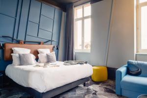 - une chambre bleue avec un lit et une chaise bleue dans l'établissement Hôtel Tandem - Boutique Hôtel, à Strasbourg