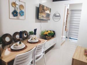 a dining room with a table and white chairs at SMDC Style Residences Condo Unit in Iloilo City