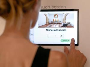 a woman looking at the screen of a hotel room at Petit Hotel Hostatgeria La Victoria in Alcudia +32 photos