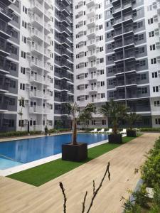 a large apartment building with a pool and palm trees at SMDC Style Residences Condo Unit in Iloilo City
