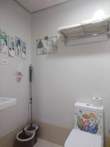 a white bathroom with a toilet and a sink at SMDC Style Residences Condo Unit in Iloilo City