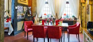 a dining room with a table and red chairs at Schifferkrug Hotel & Weinstube in Celle