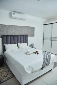 a bedroom with a large white bed with flowers on it at Serene Haven Apartments in Manzini