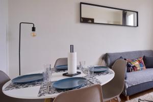 a dining room with a white table and chairs at Cosy T1 with garage near CDG | By Airnest in Le Blanc-Mesnil