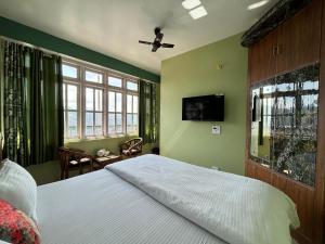 a bedroom with a bed and a tv on the wall at ZuZu Hostels in Shimla