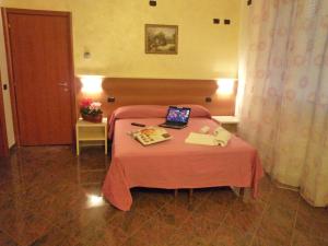 a bedroom with a bed with a laptop on it at La Volpe Pescatrice in Castellanza