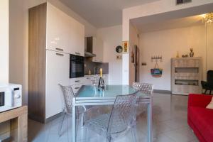 a kitchen and dining room with a glass table and chairs at AlbaChiara in Alghero