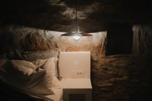 a room with a bed and a light hanging from the ceiling at Venue Villas - Folegandros in Áno Meriá