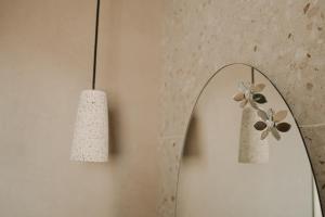 a bathroom with a mirror and a lamp and a candle at Venue Villas - Folegandros in Áno Meriá