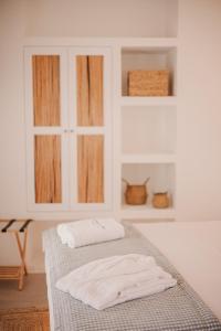 a room with a bed with two white towels on it at Venue Villas - Folegandros in Áno Meriá