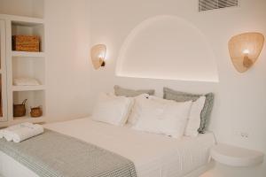 a white bedroom with a bed with white pillows at Venue Villas - Folegandros in Áno Meriá