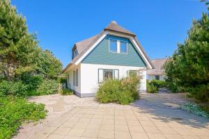 a large house with a green and white at Noorderzon - Villaparc Duynopgangh Julianadorp aan Zee in De Zandloper