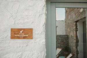a wooden sign on the side of a building at Venue Villas - Folegandros in Áno Meriá