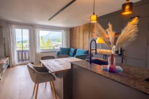 施特罗布尔Wolfgangsee Appartements的一间带桌椅的厨房和一间客厅