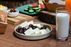 ein Teller mit Käse und Oliven neben einem Glas Milch in der Unterkunft Suite apartment in Korçë + 4 Fotos