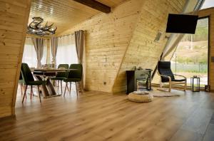 a living room with a table and chairs and a television at Cabana A Vis in Taşca