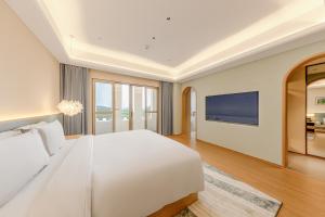 Postel nebo postele na pokoji v ubytování Tunchang Xiangshan Yunju Hotel