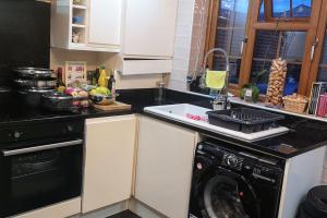 a kitchen with a dishwasher and a counter top at Cozy and warm family home in South Norwood +6 photos