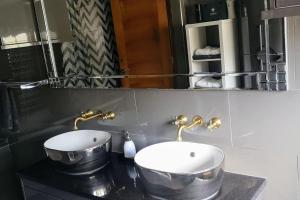 a bathroom with two sinks and a mirror at Cozy and warm family home in South Norwood