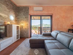 un salon avec un canapé et une télévision dans l'établissement Blue Eden Vista, à Domus de Maria