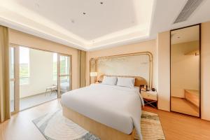 Postel nebo postele na pokoji v ubytování Tunchang Xiangshan Yunju Hotel