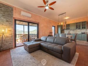 un salon avec un canapé et un ventilateur de plafond dans l'établissement Blue Eden Vista, à Domus de Maria