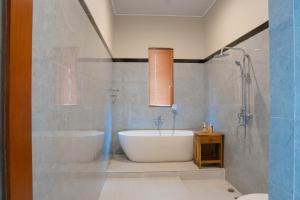 a bathroom with a bath tub and a shower at Obah Villa Ubud 1 Br Brand new private villa in Ubud