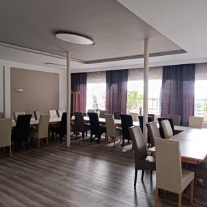 a dining room with tables and chairs and windows at Hotel Hasselberg in Kaiserslautern