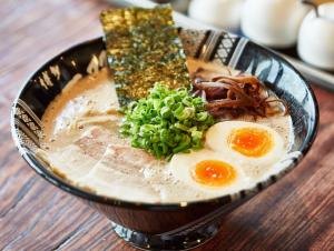 住吉にあるエルザビル707のテーブルの上には卵と肉が入ったラーメンのボウルがある