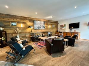 a living room with a wooden wall with furniture and a tv at Alpenlodge in Zermatt