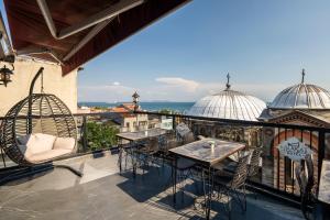a patio with tables and chairs on a balcony at York House İstanbul in Istanbul