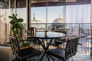 a table and chairs in a room with a large window at York House İstanbul in Istanbul